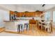Open kitchen with hardwood floors, island with seating, and stainless steel appliances at 6633 E 166Th Pl, Brighton, CO 80602