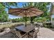 Outdoor patio area featuring a large stone table, ornate chairs, and a shade umbrella at 6633 E 166Th Pl, Brighton, CO 80602