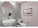 Powder room with an oval mirror, pedestal sink, modern fixtures, and neutral paint at 6633 E 166Th Pl, Brighton, CO 80602