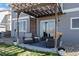 Relax on the covered back patio with comfortable seating and string lights at 11671 Elkhart, Brighton, CO 80603