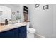 Charming powder room features a vessel sink, wood-look countertop, and stylish blue vanity at 11671 Elkhart, Brighton, CO 80603