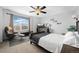 Bright bedroom with a ceiling fan, nice view from the window, and comfortable chair with ottoman for relaxing at 11671 Elkhart, Brighton, CO 80603
