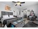 Bedroom with a ceiling fan, ensuite bathroom, bench at the foot of the bed, and rustic decor at 11671 Elkhart, Brighton, CO 80603