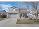 Two-story home features a two-car garage, front porch, and well-maintained lawn and landscaping at 11671 Elkhart, Brighton, CO 80603