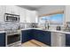 Well-lit kitchen boasts stone backsplash, stainless steel appliances, and white quartz countertops at 11671 Elkhart, Brighton, CO 80603