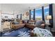 Spacious living room boasts large windows, a comfortable leather sectional sofa, and a stylish area rug at 11671 Elkhart, Brighton, CO 80603