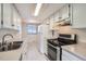 Kitchen with white cabinets, stainless steel appliances, and double sink at 8710 Carr Loop, Arvada, CO 80005