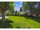 Lush green backyard featuring mature trees, offering privacy and a serene outdoor setting at 2222 E 7Th Avenue Pkwy, Denver, CO 80206