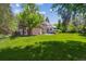 Sprawling backyard showcasing a brick home with a white-railed second-story porch and a stone patio at 2222 E 7Th Avenue Pkwy, Denver, CO 80206