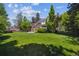 Well-manicured backyard with a brick home, patio area, lush trees and landscaping offering great outdoor space at 2222 E 7Th Avenue Pkwy, Denver, CO 80206
