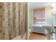 Updated bathroom with a new sink, toilet, shower with a curtain, and a large window for natural light at 2222 E 7Th Avenue Pkwy, Denver, CO 80206