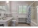 Full bathroom with classic white fixtures, tile surround, and a window with shutters at 2222 E 7Th Avenue Pkwy, Denver, CO 80206