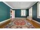 Bright living room featuring dark teal walls, white trim, hardwood floors, and white window shutters at 2222 E 7Th Avenue Pkwy, Denver, CO 80206