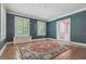 Bright living room featuring dark teal walls, white trim, hardwood floors, and white window shutters at 2222 E 7Th Avenue Pkwy, Denver, CO 80206
