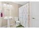 Bathroom with a pedestal sink, shower with floral curtain, and neutral walls at 8389 Owl Roost Ct, Parker, CO 80134