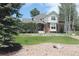 Beautiful two-story home with a well-manicured lawn, stone accents, and mature trees at 8389 Owl Roost Ct, Parker, CO 80134