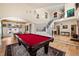 Open-concept living room boasts hardwood floors, staircase, and a red billiard table for entertainment at 8389 Owl Roost Ct, Parker, CO 80134