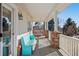 Relaxing covered porch with a painted bench, brick accents, and white railings, perfect for enjoying the outdoors at 8389 Owl Roost Ct, Parker, CO 80134