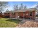 Backyard view of the patio, lawn, and brick exterior of the home at 2165 S Nucla Way, Aurora, CO 80013
