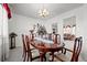 Elegant dining room with a polished wood table, seating for six, chandelier, and view into living area at 2165 S Nucla Way, Aurora, CO 80013