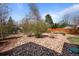 Landscaped yard with trees, shrubs, rocks, and a wood fence at 2165 S Nucla Way, Aurora, CO 80013