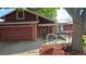Home's exterior featuring a two-car garage, handicap ramp, brick accents, and solar panels on the roof at 4543 Cathay St, Denver, CO 80249