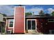 Cozy home exterior featuring a red facade, a chimney, sliding glass door, and efficient solar panels at 4543 Cathay St, Denver, CO 80249