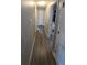 Hallway with neutral paint, wood-look flooring, and doorways leading to various rooms and laundry at 4543 Cathay St, Denver, CO 80249