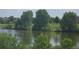 Scenic lake view with lush green trees, grassy hillside and peaceful water reflecting the sky at 4543 Cathay St, Denver, CO 80249