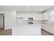 Modern kitchen boasts white cabinets, stainless steel appliances, and a center island at 45916 Gentry Ave, Bennett, CO 80102