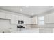Bright kitchen showcasing white cabinets, stainless steel appliances, and stylish countertops at 45916 Gentry Ave, Bennett, CO 80102