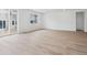 Spacious living room with modern wood floors, white walls, and sliding glass doors at 45916 Gentry Ave, Bennett, CO 80102