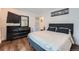 Bedroom featuring wood floors and a modern dresser with wall-mounted TV at 2286 S Pitkin Way # A, Aurora, CO 80013