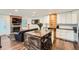 Open living room view with a brick fireplace, dark leather sofa and an eat in kitchen island at 2286 S Pitkin Way # A, Aurora, CO 80013