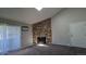 View of the carpeted living room featuring a large stone fireplace, a skylight, and access to a sliding glass door at 10150 E Virginia Ave # 308, Denver, CO 80247