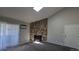 View of the carpeted living room featuring a large stone fireplace, a skylight, and access to a sliding glass door at 10150 E Virginia Ave # 308, Denver, CO 80247