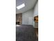 The spacious carpeted living room features a skylight, view to kitchen, and a striking stone fireplace at 10150 E Virginia Ave # 308, Denver, CO 80247