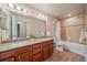 Bathroom with double vanity, granite countertop and tiled shower/tub at 2420 Nicholson St, Berthoud, CO 80513