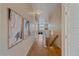 Light-colored hallway with hardwood floors, artwork, and staircase at 2420 Nicholson St, Berthoud, CO 80513