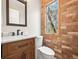 Cozy bathroom with custom vanity, brick accent wall, and a window at 2578 E Nichols Cir, Centennial, CO 80122