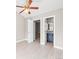 Bedroom with light wood floors, ceiling fan, and doorway leading to ensuite bathroom at 2578 E Nichols Cir, Centennial, CO 80122
