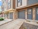 Close-up of townhome exteriors with stone accents, garages, and welcoming entryways showcasing detailed design at 2578 E Nichols Cir, Centennial, CO 80122