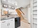 Bright kitchen with stainless steel appliances, brick backsplash, and staircase at 2578 E Nichols Cir, Centennial, CO 80122