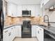 Updated kitchen with white cabinets, black appliances, brick backsplash, and modern fixtures at 2578 E Nichols Cir, Centennial, CO 80122