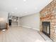 Bright living room with stone fireplace, light wood floors, and open layout, seamlessly connecting to the kitchen at 2578 E Nichols Cir, Centennial, CO 80122