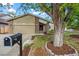 Inviting exterior with a charming front yard, a two-car garage, and mature tree at 2090 S Fairplay St, Aurora, CO 80014