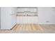 Close up of a bright kitchenette with white cabinets, a sink, and an updated floor at 2090 S Fairplay St, Aurora, CO 80014