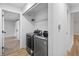 Modern laundry room features updated appliances, white walls, and wood floors at 2090 S Fairplay St, Aurora, CO 80014