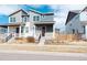 Charming two-story home with a covered front porch, a well manicured lawn, and an attractive red door at 21821 E 7Th Ave, Aurora, CO 80018