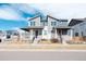Charming two-story home with a covered front porch, a well manicured lawn, and an attractive red door at 21821 E 7Th Ave, Aurora, CO 80018